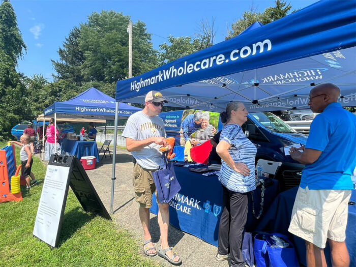 People in front of tabling event with tent .