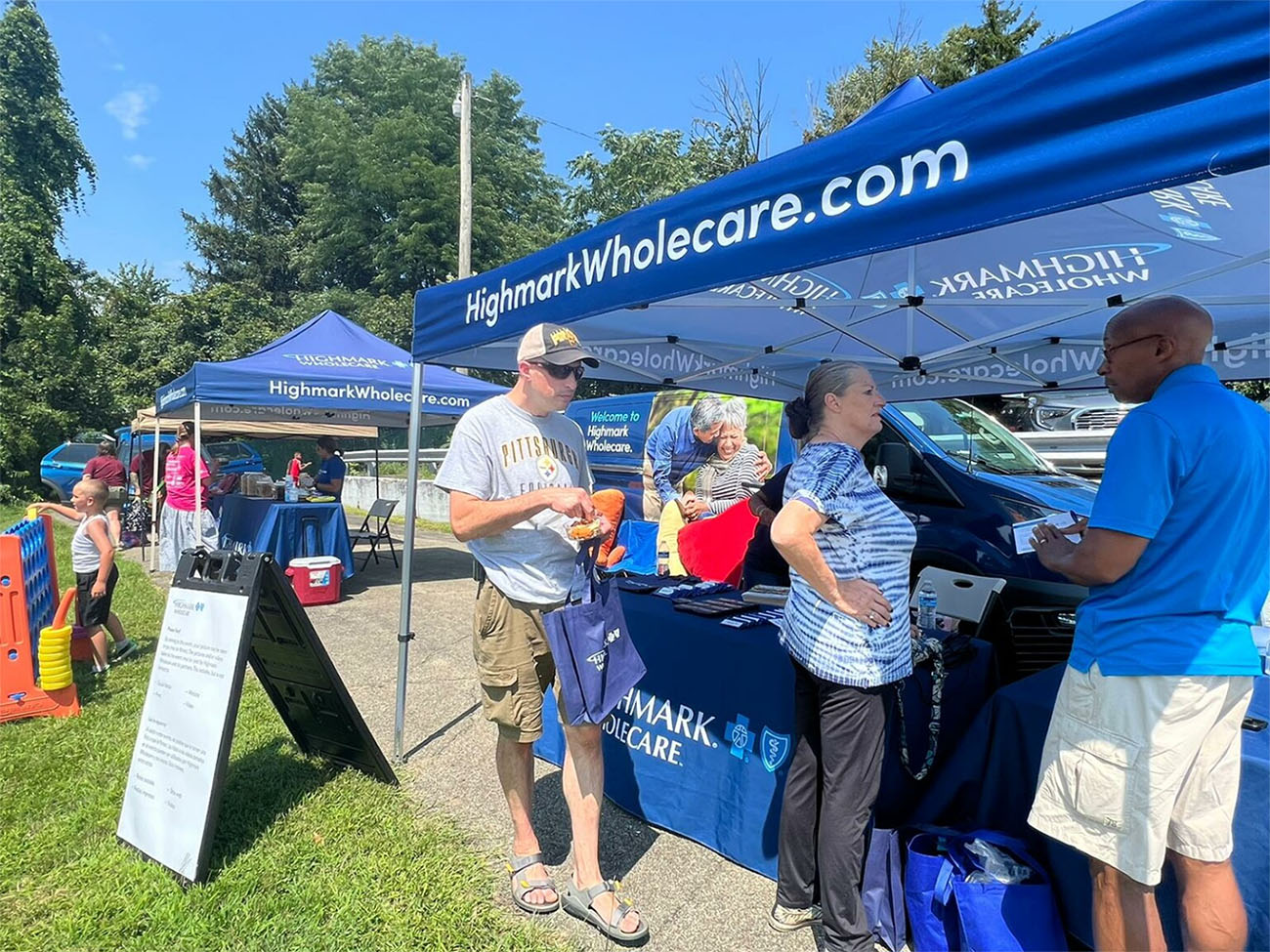 People in front of tabling event with tent .